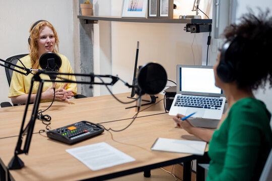 Happy diverse radio hosts recording podcast in studio
