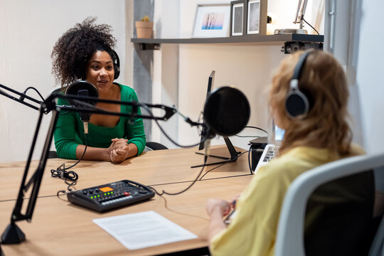 Happy diverse radio hosts recording podcast in studio