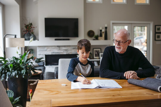 Mature Man Helping Kid With Schoolwork