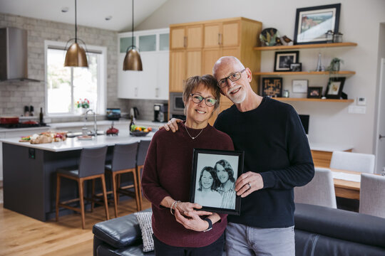 Mature Couple Holding Old Photograph.