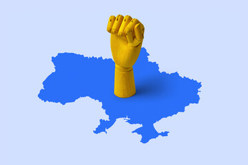 Wooden mannequin hand on blue map of Ukraine