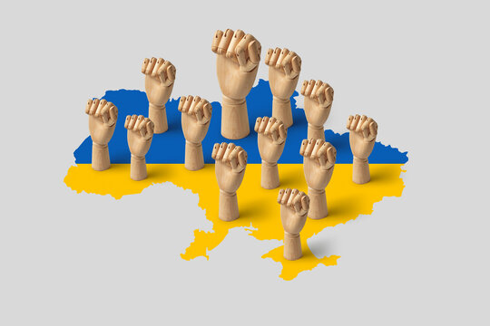 Wooden mannequin fists on blue and yellow map of Ukraine