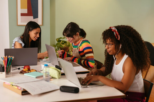 Diverse students doing homework in cozy coffee shop