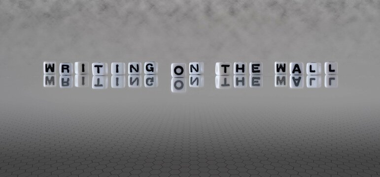 writing on the wall word or concept represented by black and white letter cubes on a grey horizon background stretching to infinity