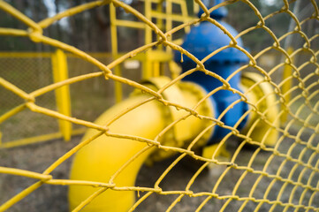 Blurred large shut-off mechanism on the gas supply pipe. Shut-off valve to stop the pumping of gas through the pipe line. Defocused