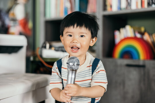 baby boy with microphone smiling singing