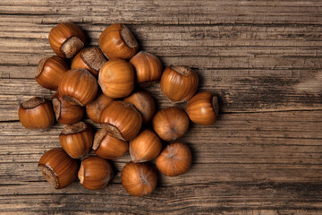 Bunch of hazelnut not purified on old wood background. View from above