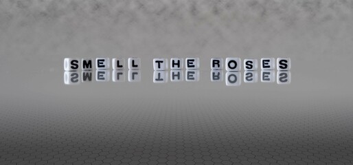 smell the roses word or concept represented by black and white letter cubes on a grey horizon...