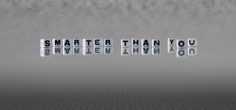 smarter than you word or concept represented by black and white letter cubes on a grey horizon background stretching to infinity