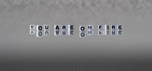 you are on fire word or concept represented by black and white letter cubes on a grey horizon...
