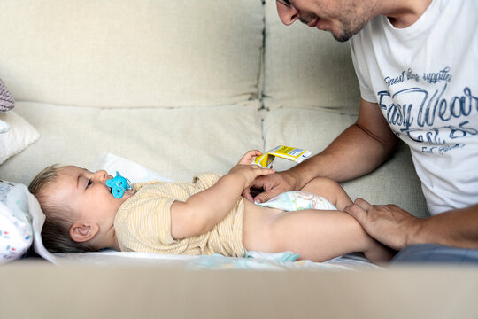 Unrecognizable father changing diaper on baby