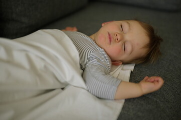 Portrait of sweet little boy sleeping on couch