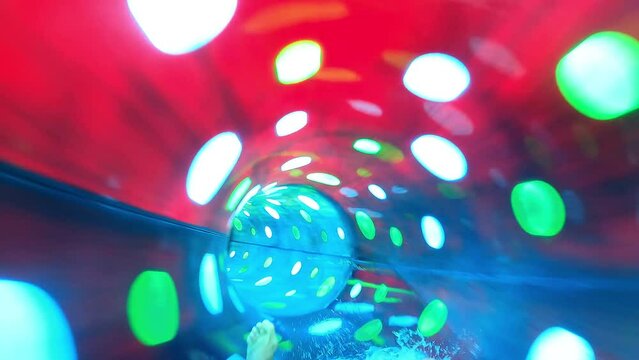 Teenager boy have fun in a closed slider at water Park. Fun on water. Enjoying water slider ride. Rider POV. Point of view in aqua park tube slide. Summer time. Multicolors view