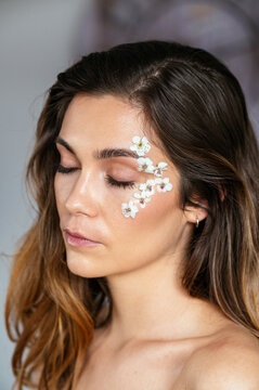 side view Young woman model with flower petals on face