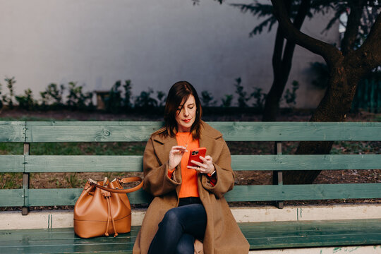 Adult female browsing cellphone on street