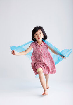 Asian little girl playing game with silk scarf