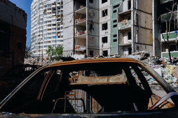 Chernihiv Ukraine 2022: Burned car interior against the background of destroyed buildings after the...