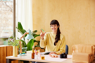 Friendly female entrepreneur showing perfume