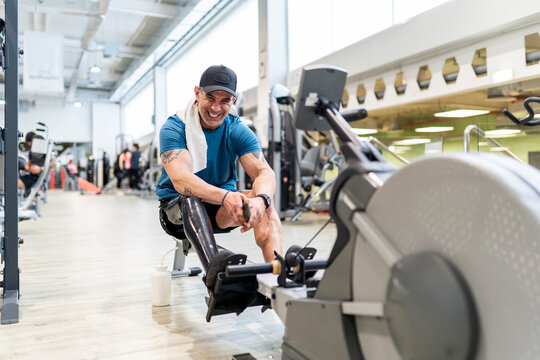 Delighted fit man with prosthetic leg in gym