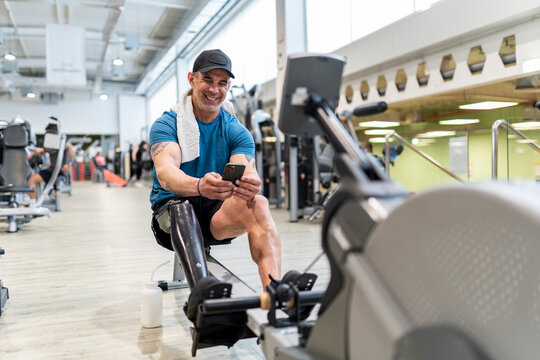 Happy sportsman with bionic limb in fitness center