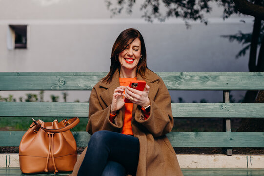 Laughing lady checking notifications on smartphone
