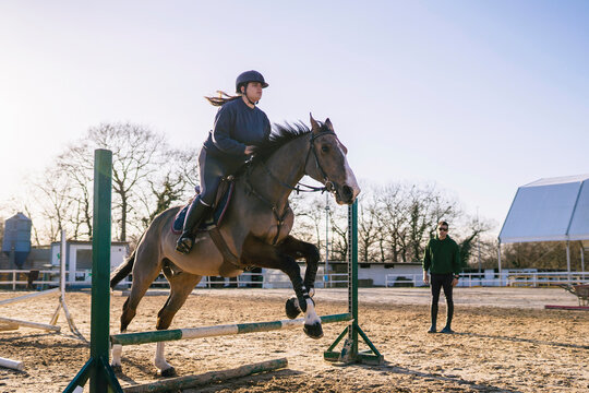 Lady during horseback lesson in paddock