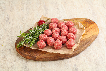 Raw uncooked beef meatballs served rosemary