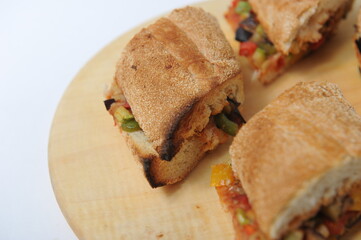 Panini with vegetables and toasted bread on a plate.