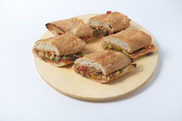 Panini with vegetables and toasted bread on a plate.