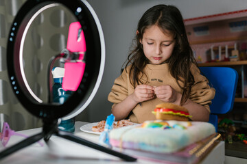 Preteen food blogger recoding video on smartphone