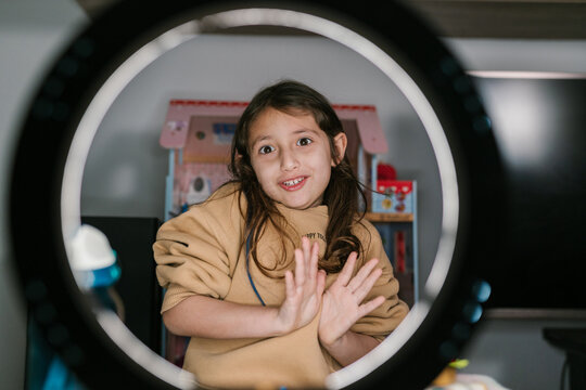 Cheerful preteen blogger recording video at home