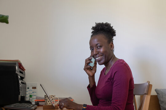 portrait of smiling woman working from home, answer phone call