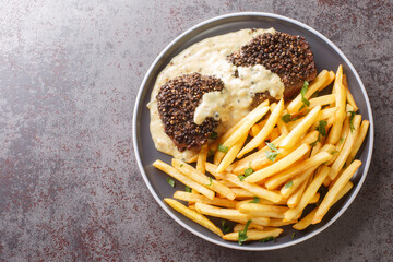 Classic French dish steak au poivre is a filet mignon with a crunchy peppercorn crust and rich...