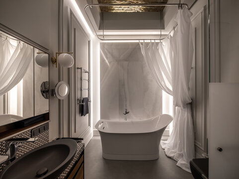 Illuminated interior in modern style with freestanding bathtub