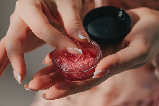 Anonymous woman holding container with  sugar scrub - beauty care 