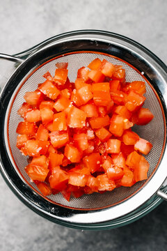 Straining chopped tomatoes