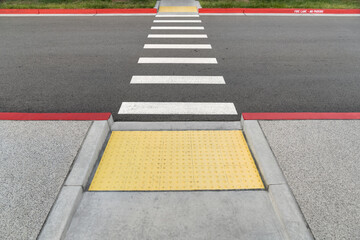Closeup view at colorful crosswalk with tactile paving