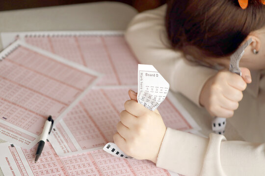 A sad young girl suffers from a loss after looking the unlucky result of the lottery gambling. The concept of losing the lottery and spend money