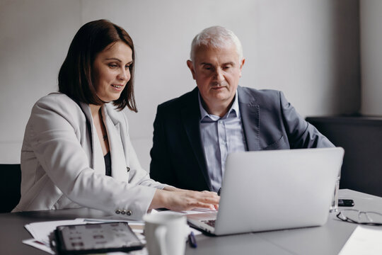 Businesspeople analyzing data on laptop