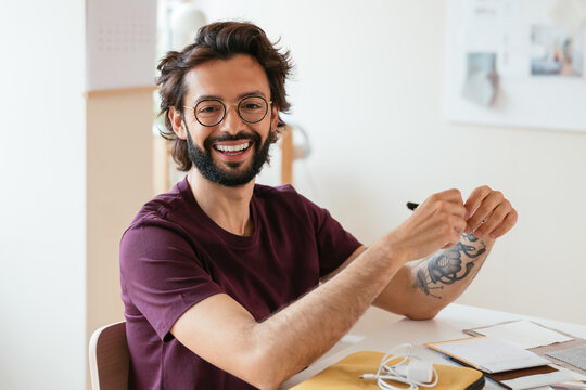 Cheerful male designer sitting at table