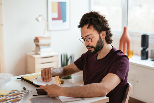 Hispanic male designer examining samples