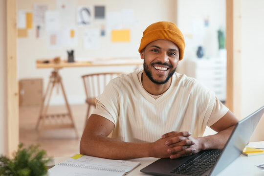 Cheerful black man in home office