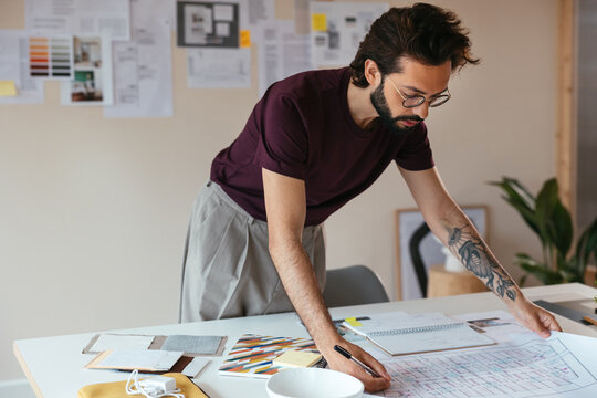 Male architect making notes on draft