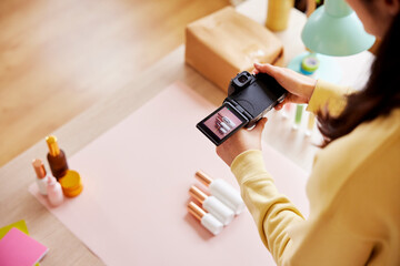 Unrecognizable entrepreneur taking photos of bottles