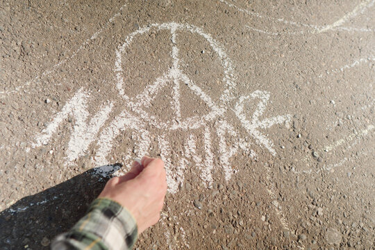 Woman drawing anti-war art with chalk on the street