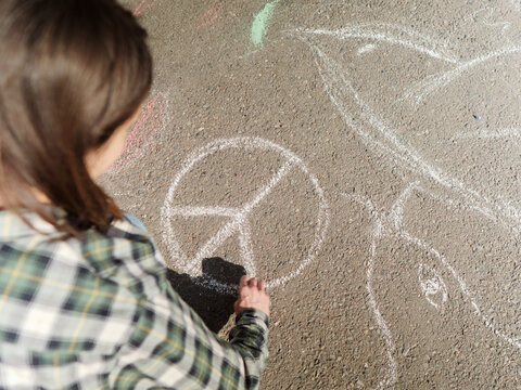 Woman drawing anti-war art with chalk on the street