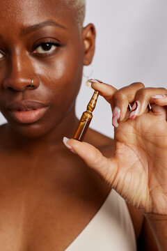 Woman showing ampoule of moisturizing serum