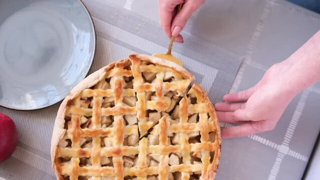 Apple pice cake preparation series - woman taking slicie of a traditional pie - top view
