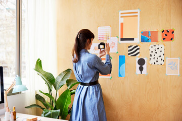 Young freelancer shooting pictures on wall