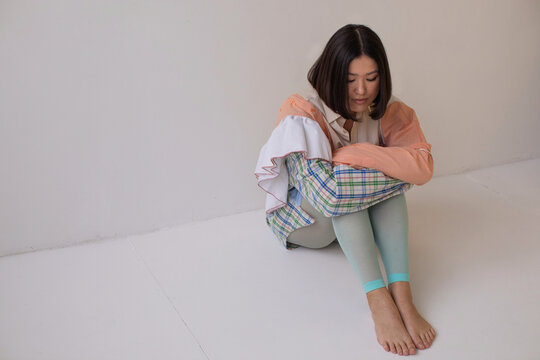 Brunette model sitting on floor in patchwork clothes